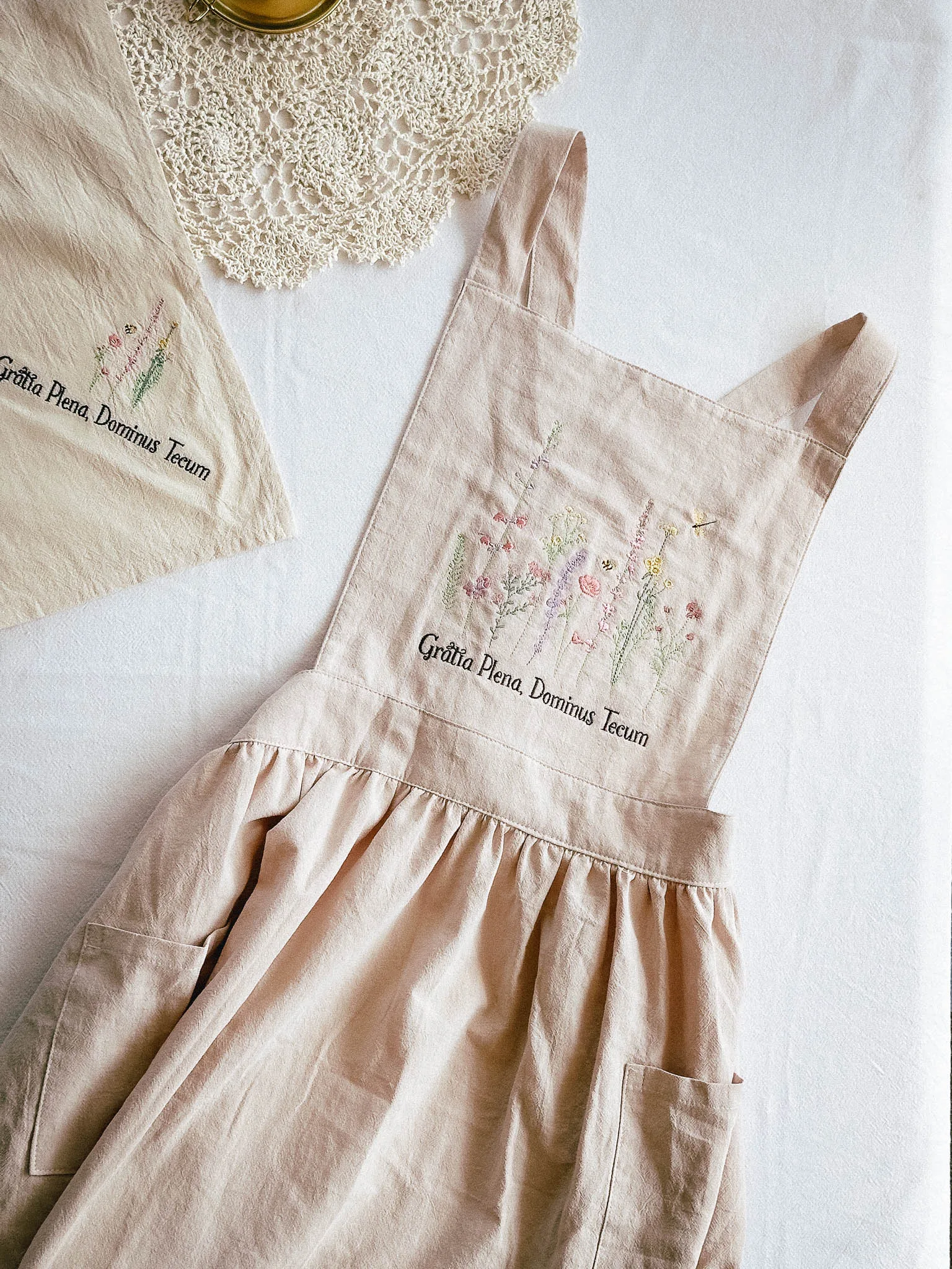 Catholic lifestyle gifts collection featuring embroidered kitchen apron and napkin set